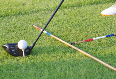 A picture of golf alignment sticks on the ground with a golf ball and club